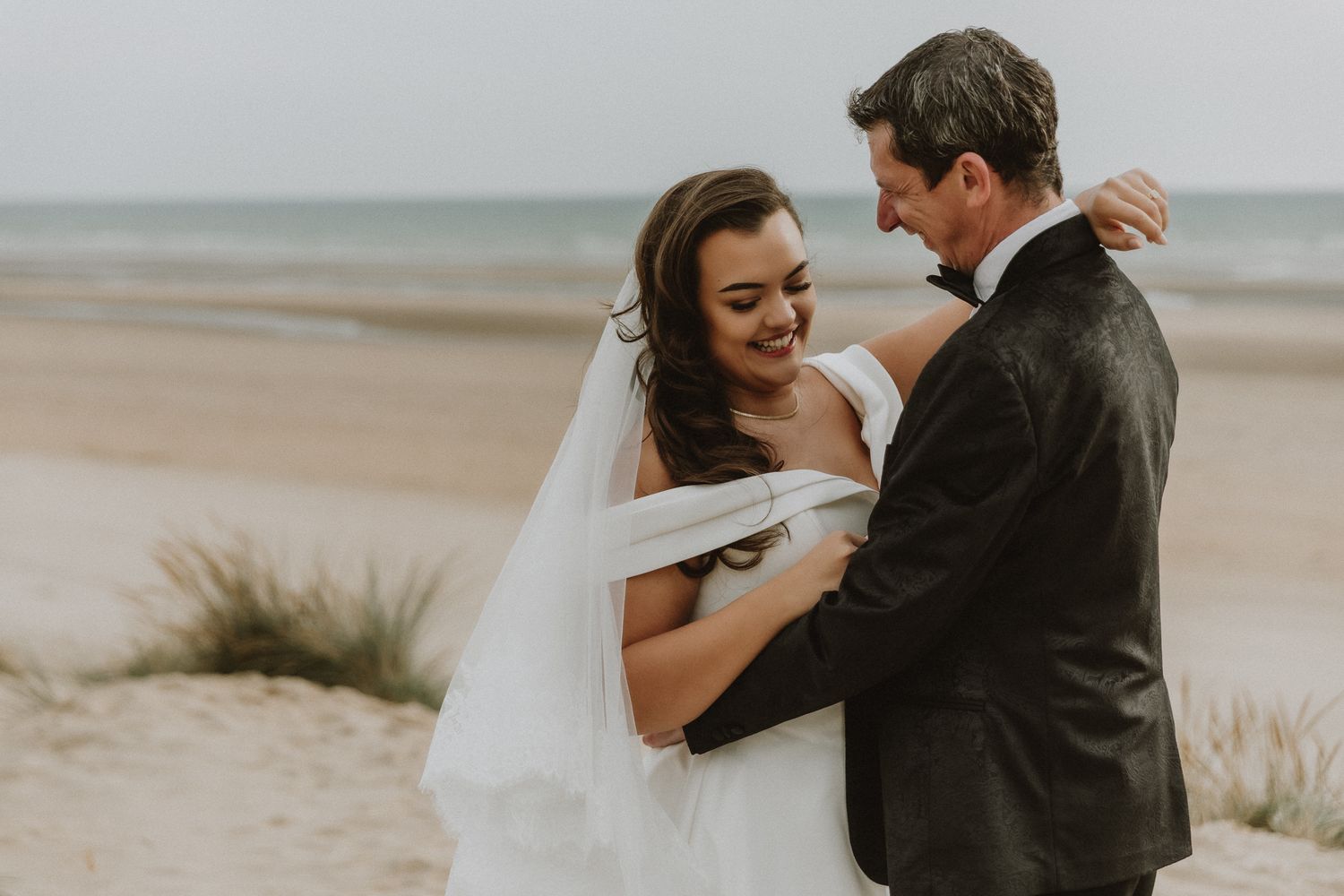 coastal elopement portrait in Kent – couple standing on sandy ridge