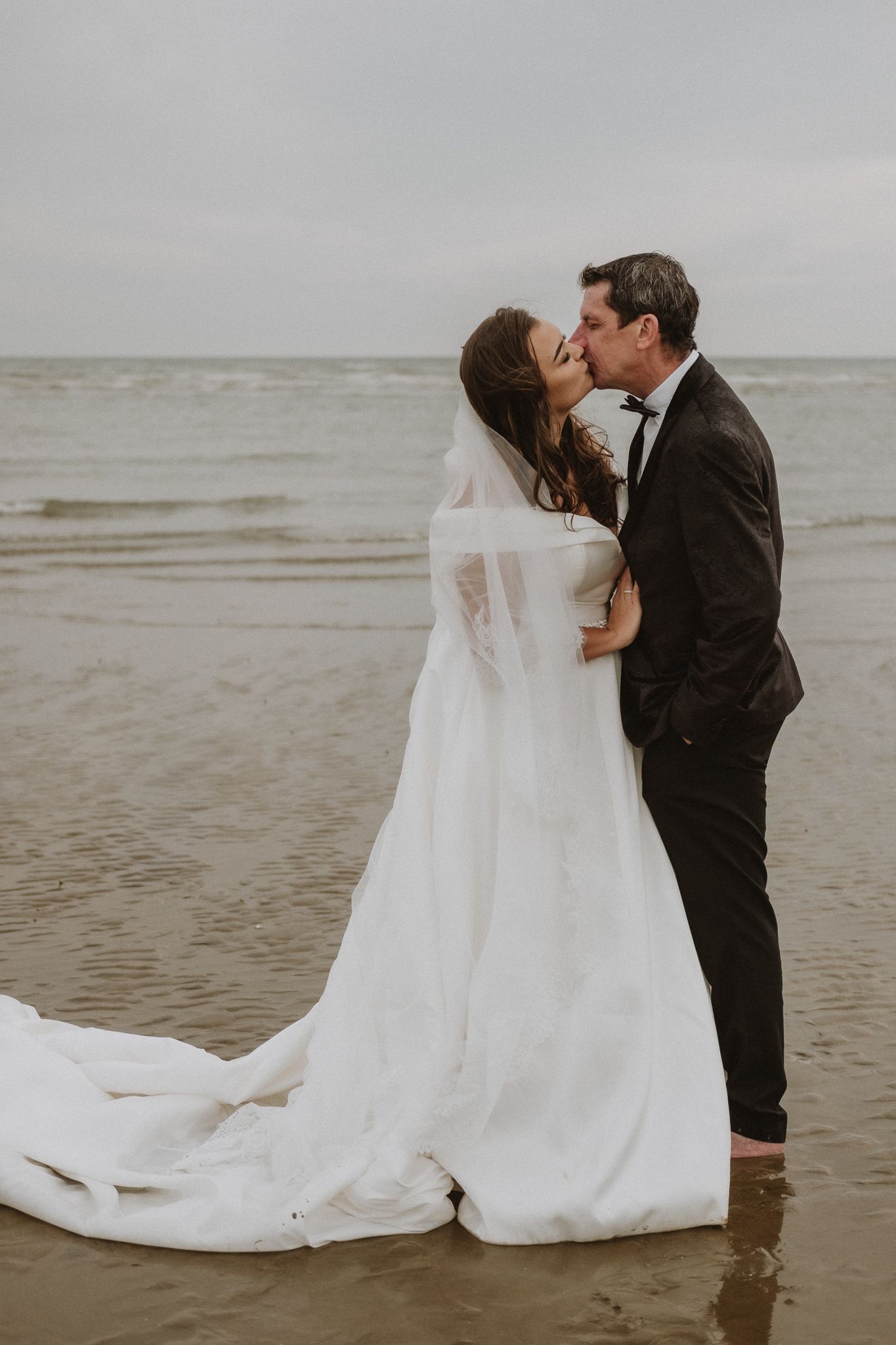 intimate beach wedding photography in London – couple embracing on shoreline