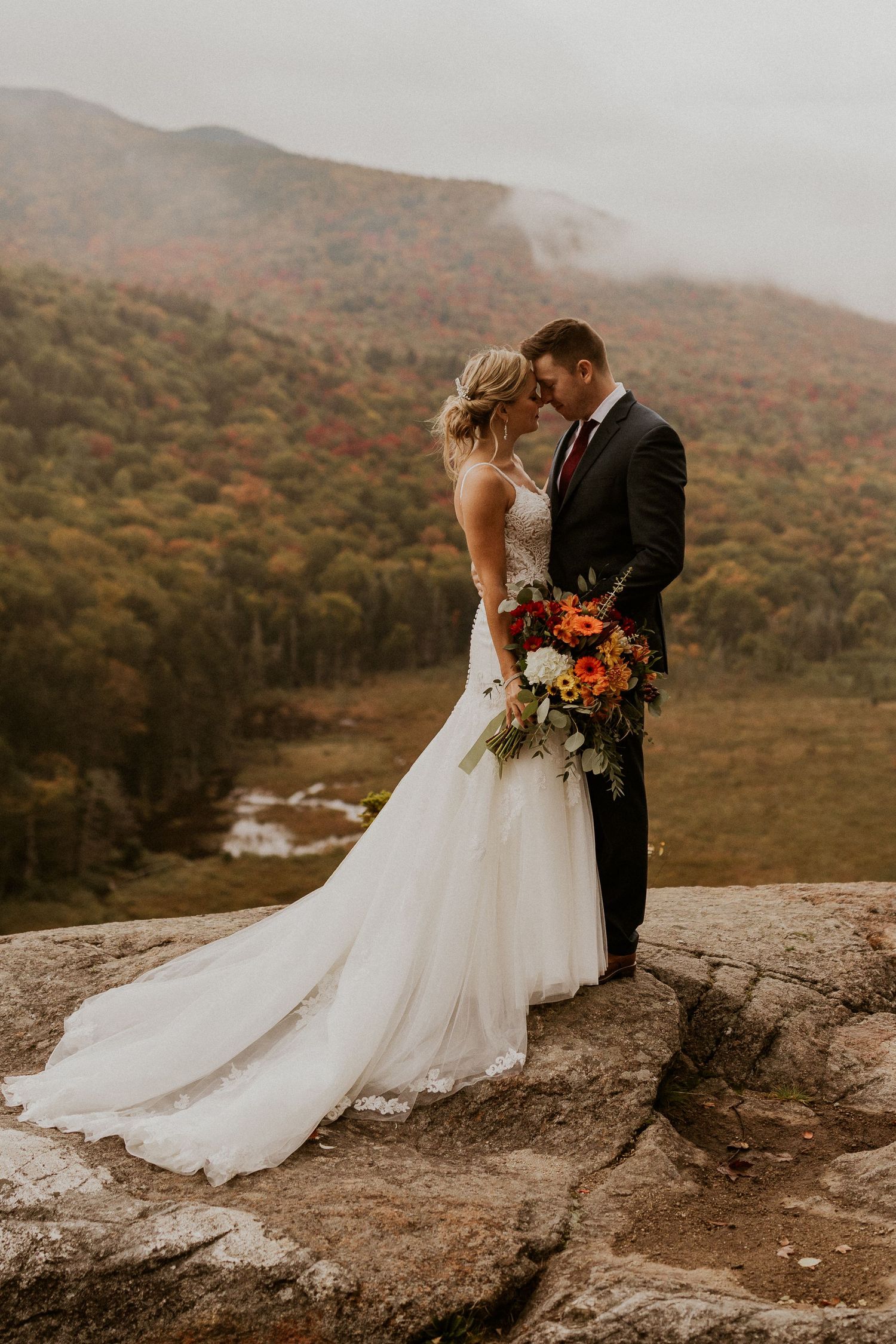 Newlyweds posing for mountaintop portraits in the White Mountain National Forest of New Hampshire.