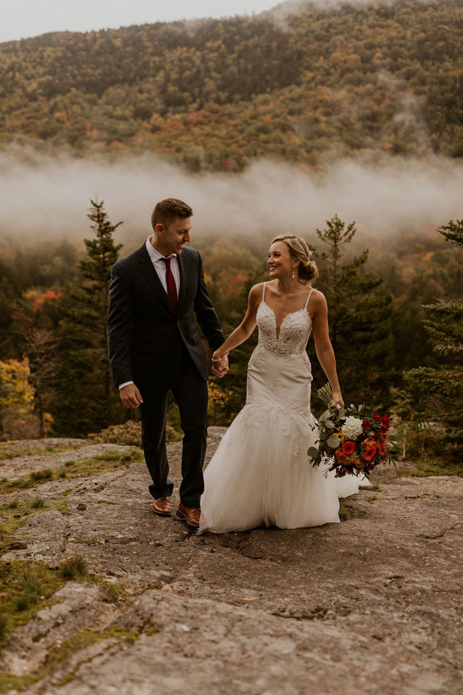 Newlyweds posing for mountaintop portraits in the White Mountain National Forest of New Hampshire.
