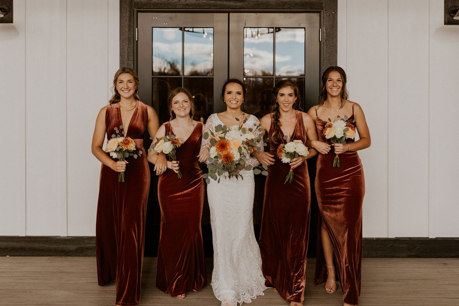 Abbie and her bridesmaids walking together, arm in arm.