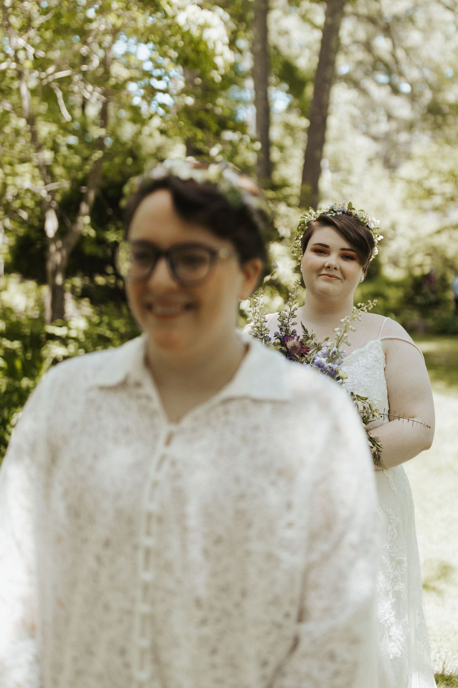 Wedding portrait in a sunny garden setting with white lace attire.
