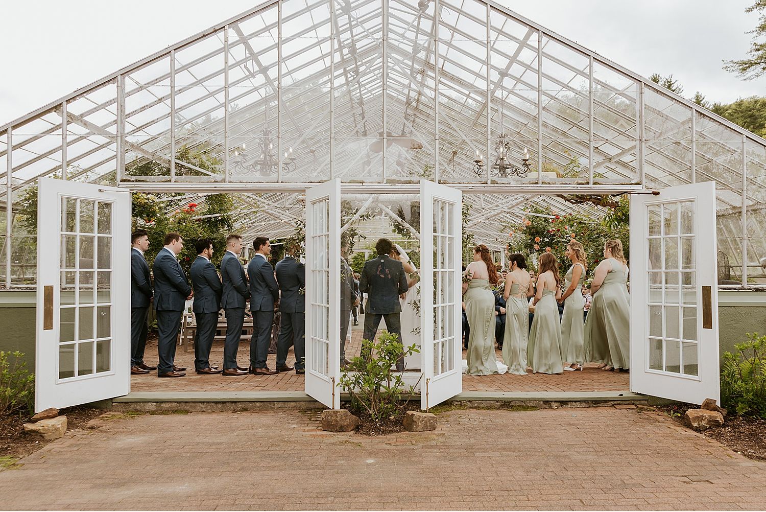 Panoramic view of a glass greenhouse wedding venue with white trim and elegant architecture.