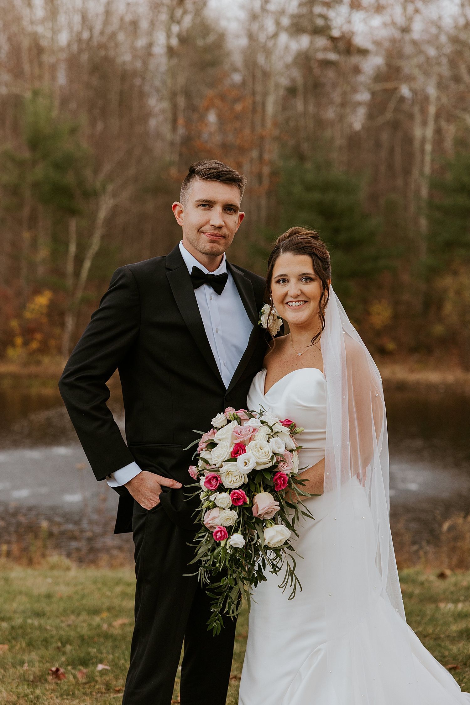 Bride and groom posing outdoors near a pond at their New Hamsphire wedding - wedding photography advice