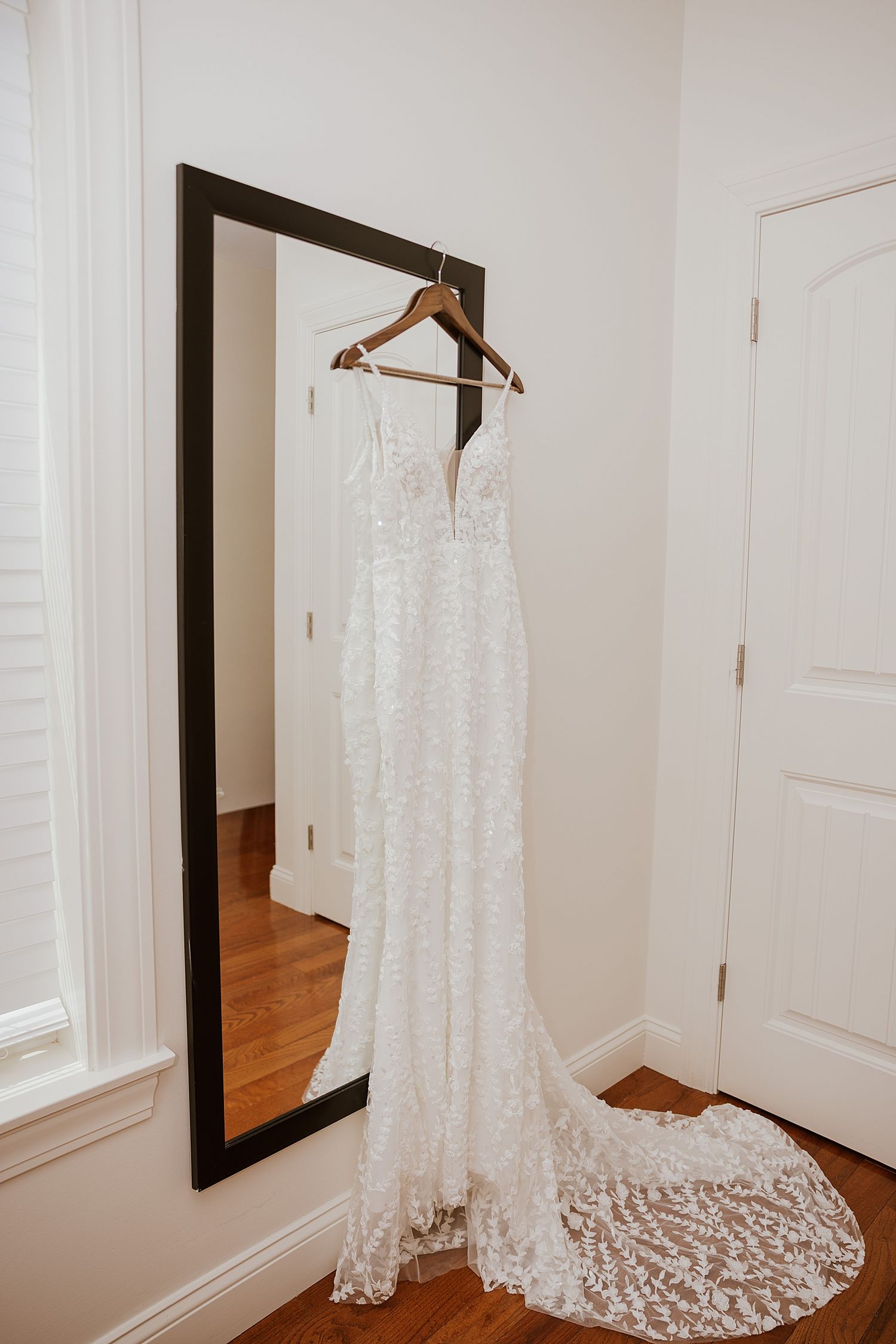 White lace bridal gown with train hanging up for a New Hampshire wedding
