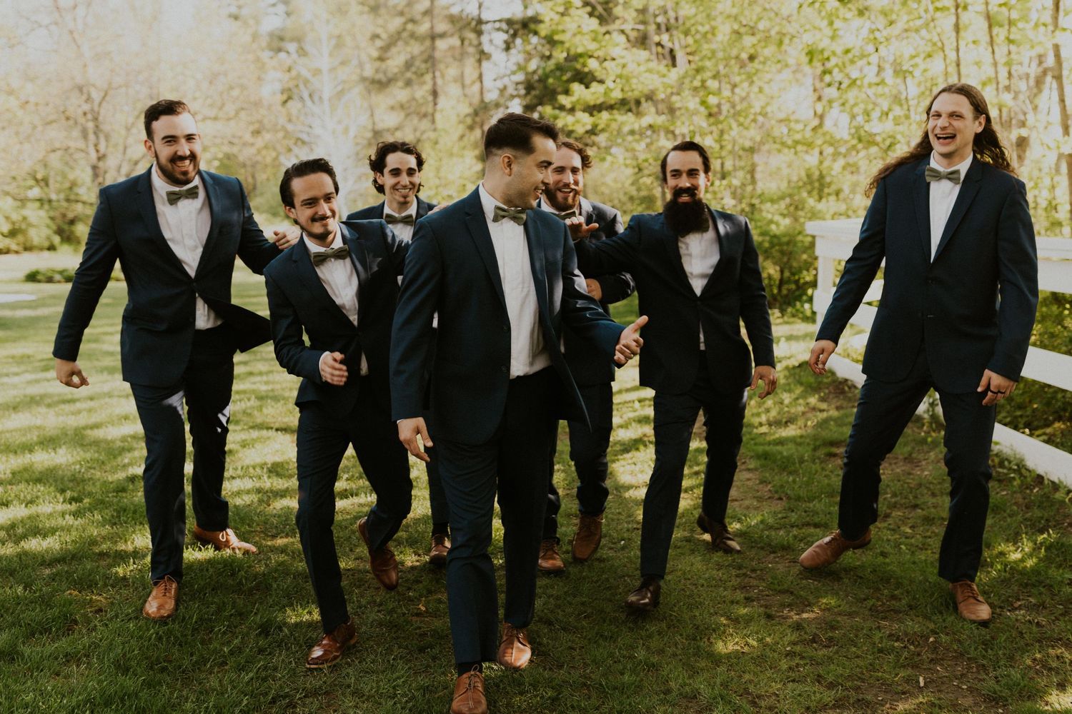 Groomsmen group photo with everyone walking and laughing and having fun together.