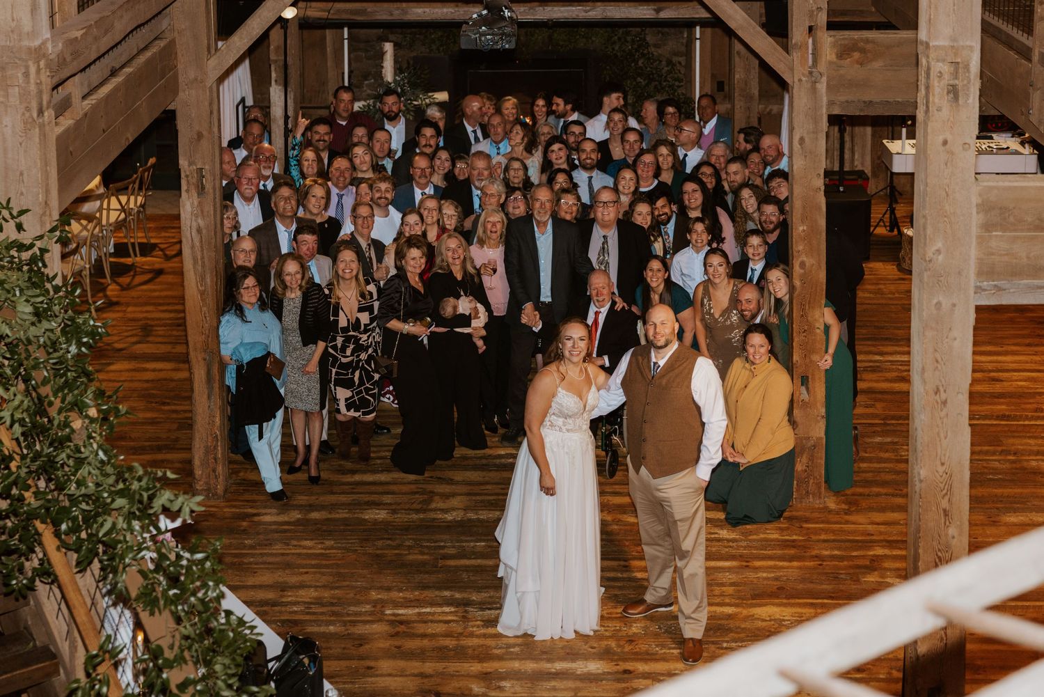 Wedding guests gathered in a rustic barn venue for the reception celebration.