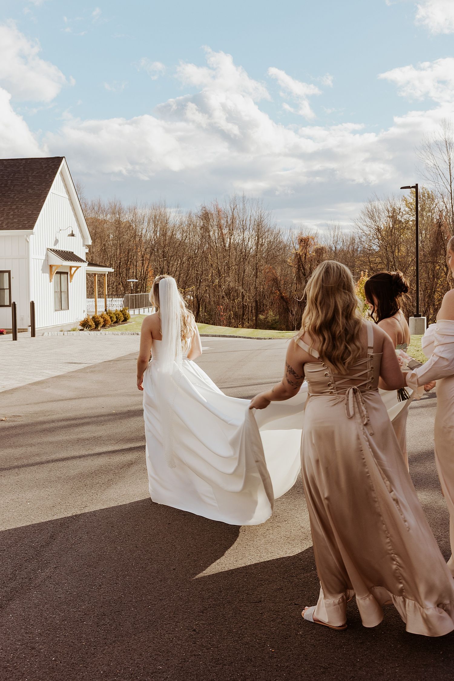 Bride and her bridesmaids walking to her wedding ceremony at Hyla Brook Estate in New Hampshire