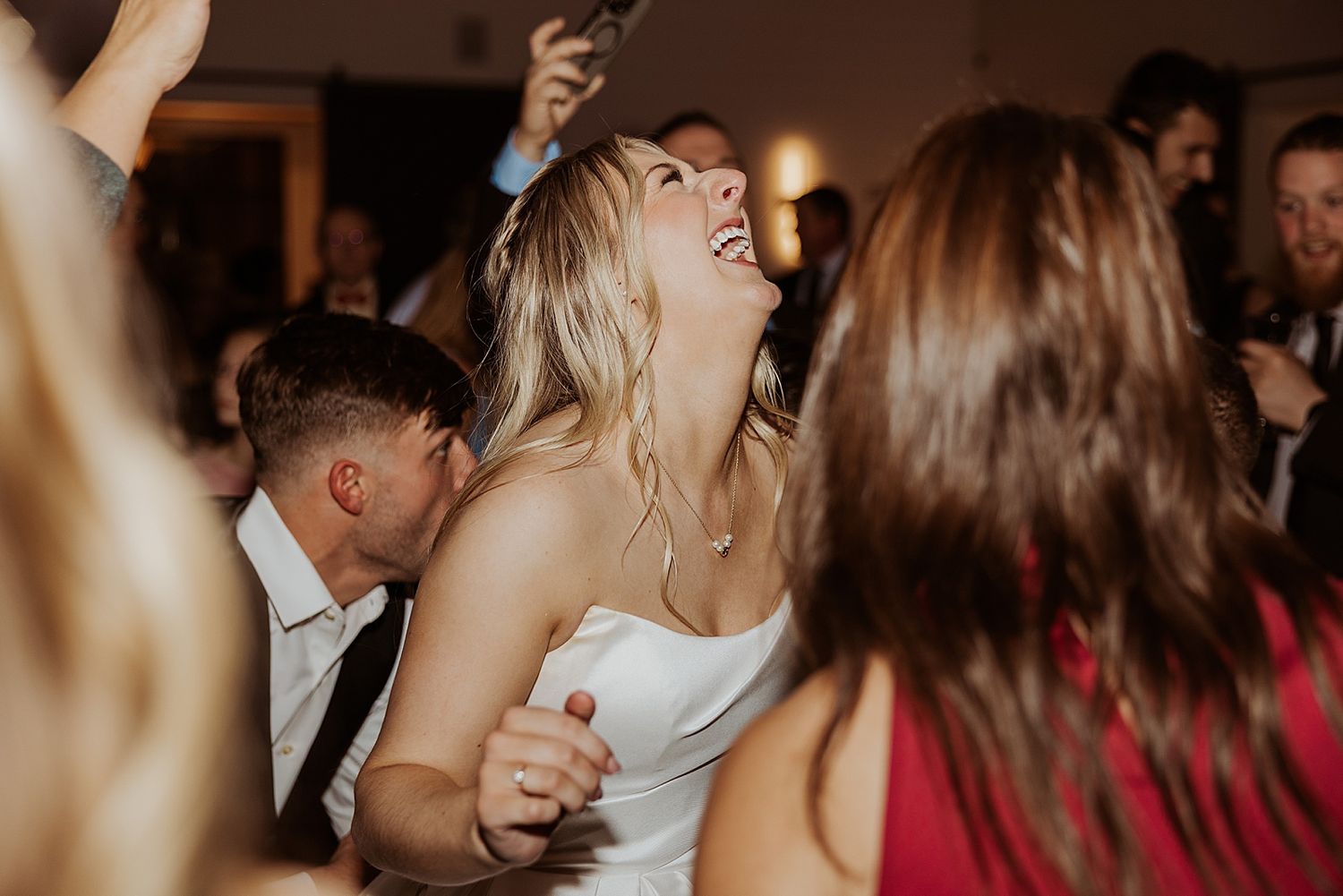 Bride laughing on the dance floor with her guests at her NH wedding