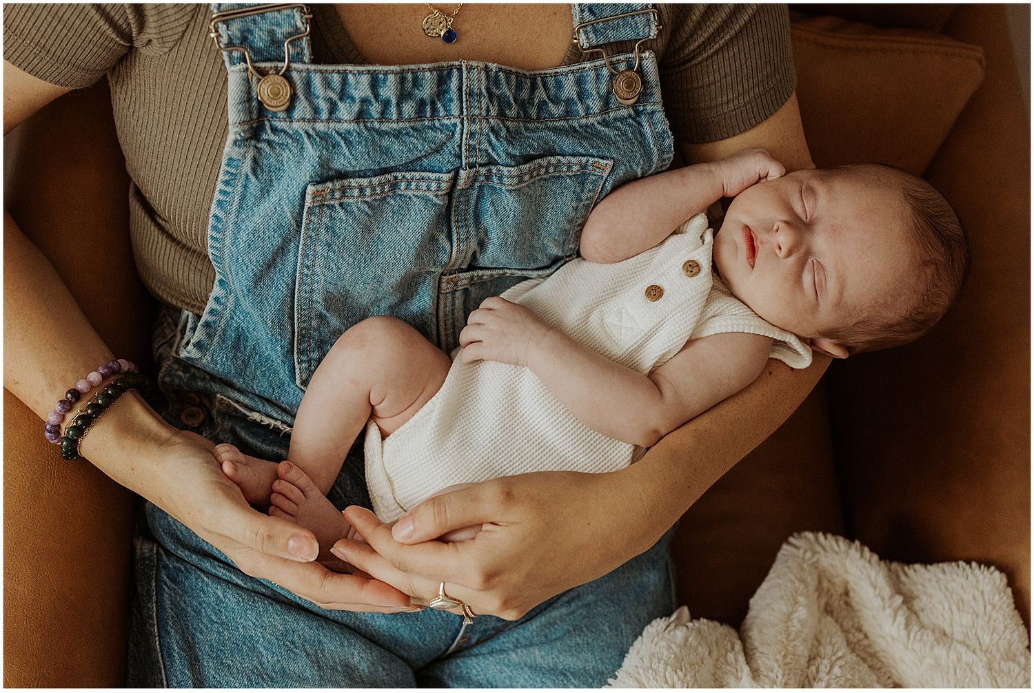 NH mom holding her baby while taking newborn family photos at home