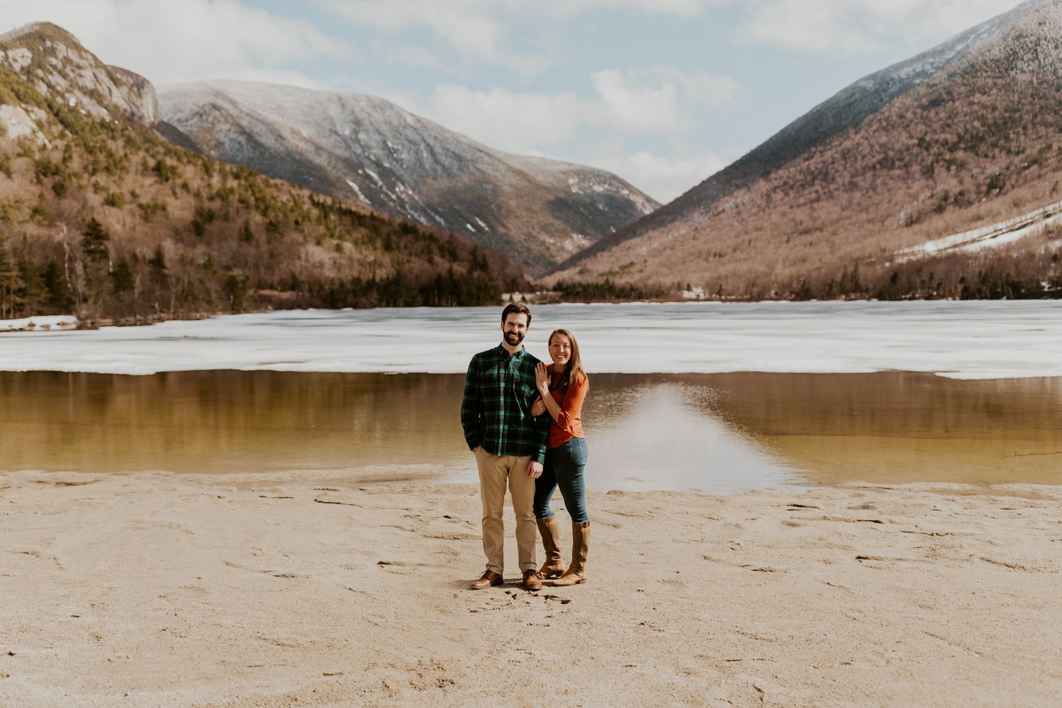 A happy couple standing in front of Echo Lake in Franconia Notch State Park