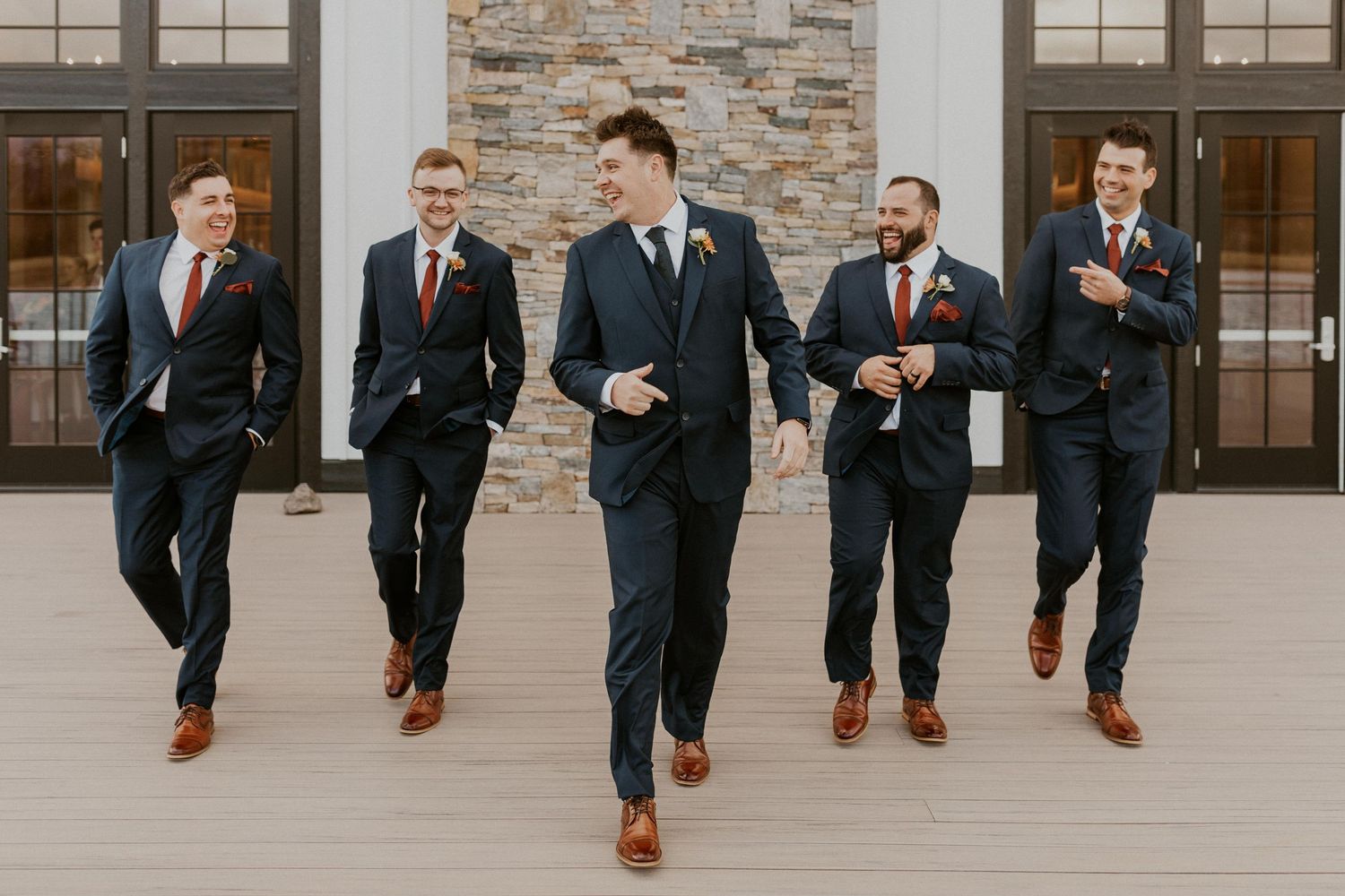 The groom and groomsmen walking together and joking around.