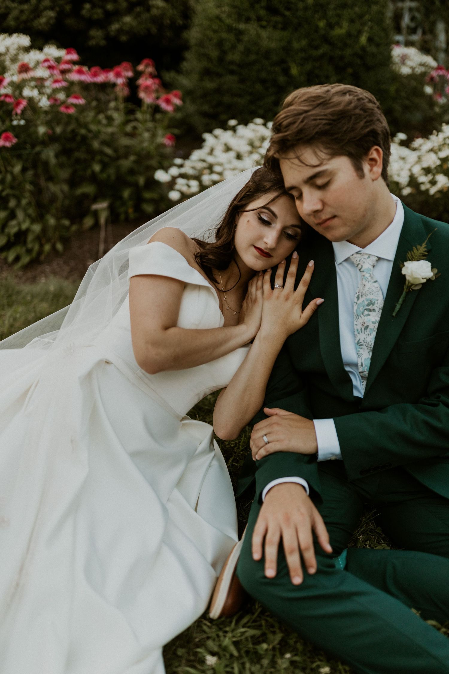 Romantic wedding portrait in a garden with blooming flowers.