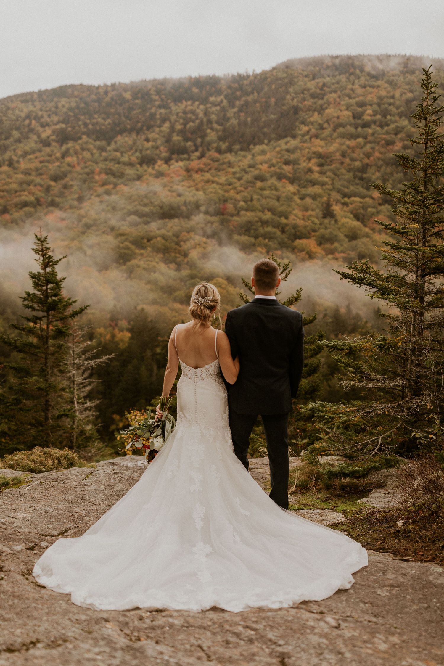 Newlyweds posing for mountaintop portraits in the White Mountain National Forest of New Hampshire.