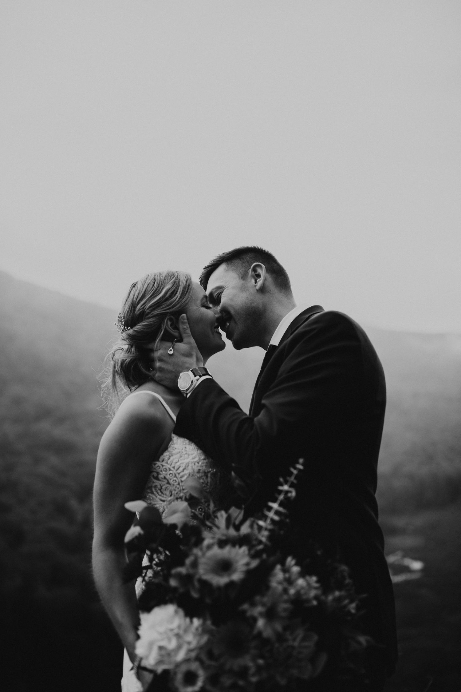 Newlyweds posing for mountaintop portraits in the White Mountain National Forest of New Hampshire.