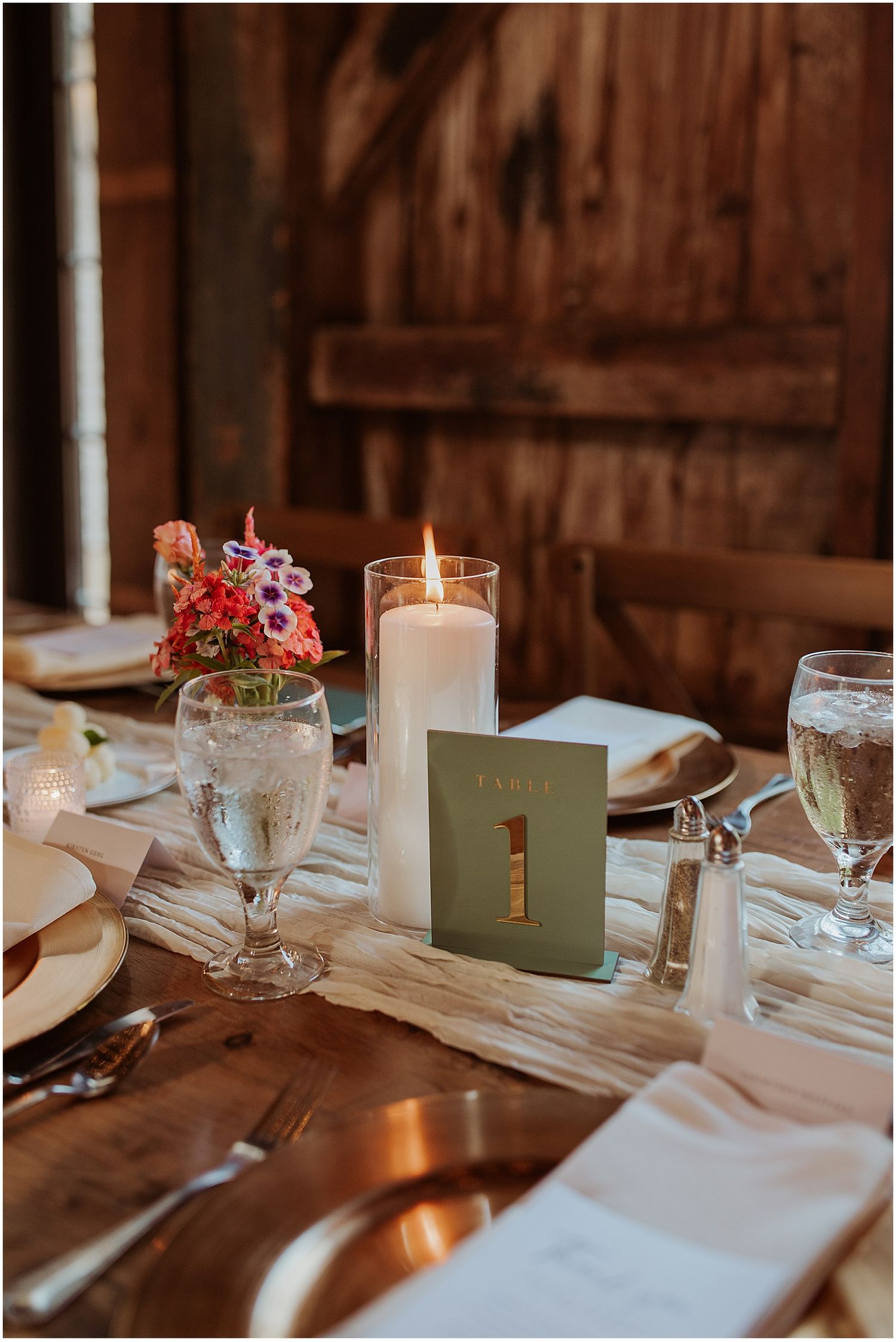 Wedding reception table details with white candles, place settings and mint green accents.