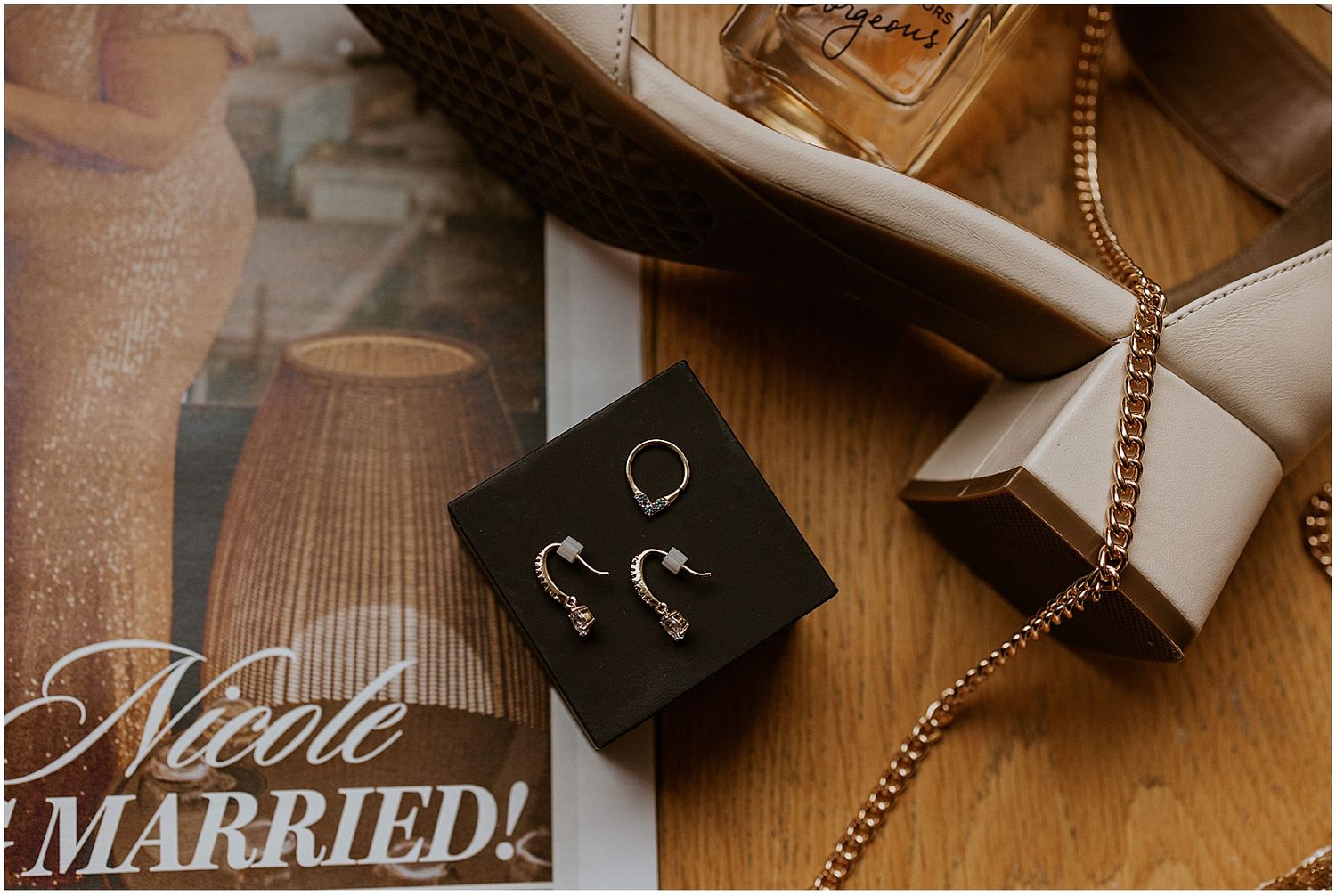 Wedding accessories and decorative items artfully arranged on wooden surface.