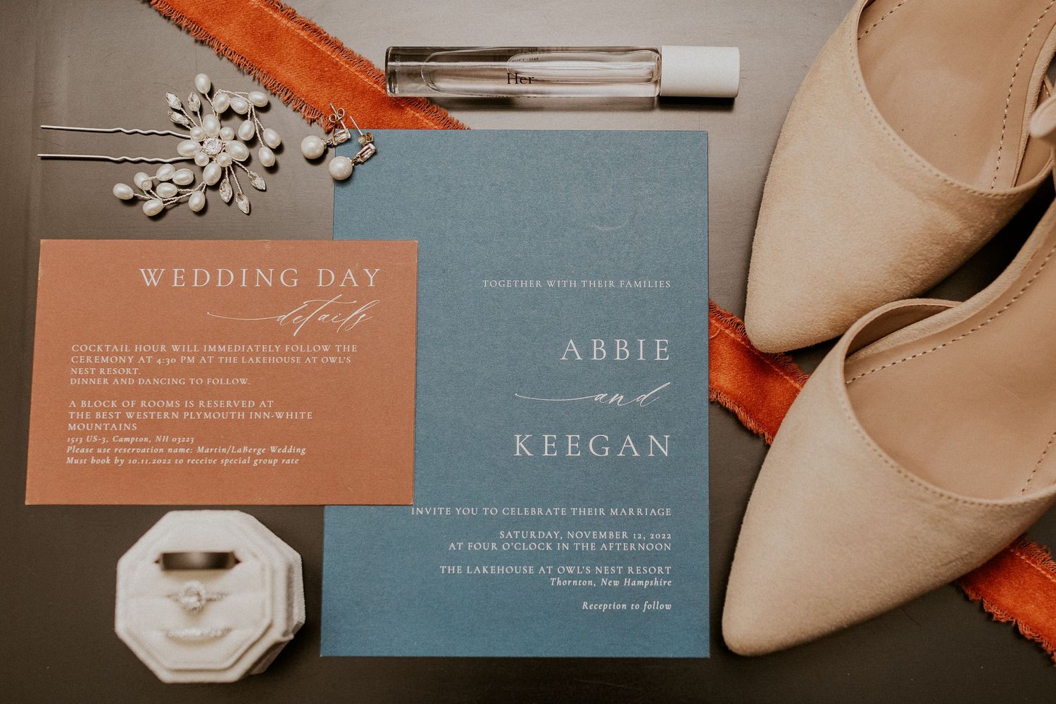 A flat lay photograph for Abbie and Keegan's wedding day. The photograph includes wedding stationary, jewelry, and shoes