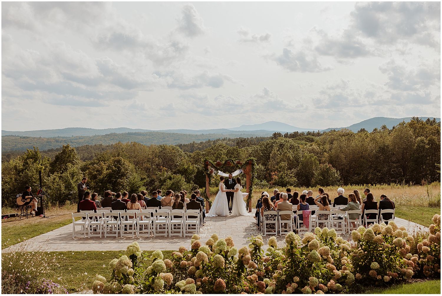 An outdoor wedding ceremony with mountains in the background at Longlook Farm in NH