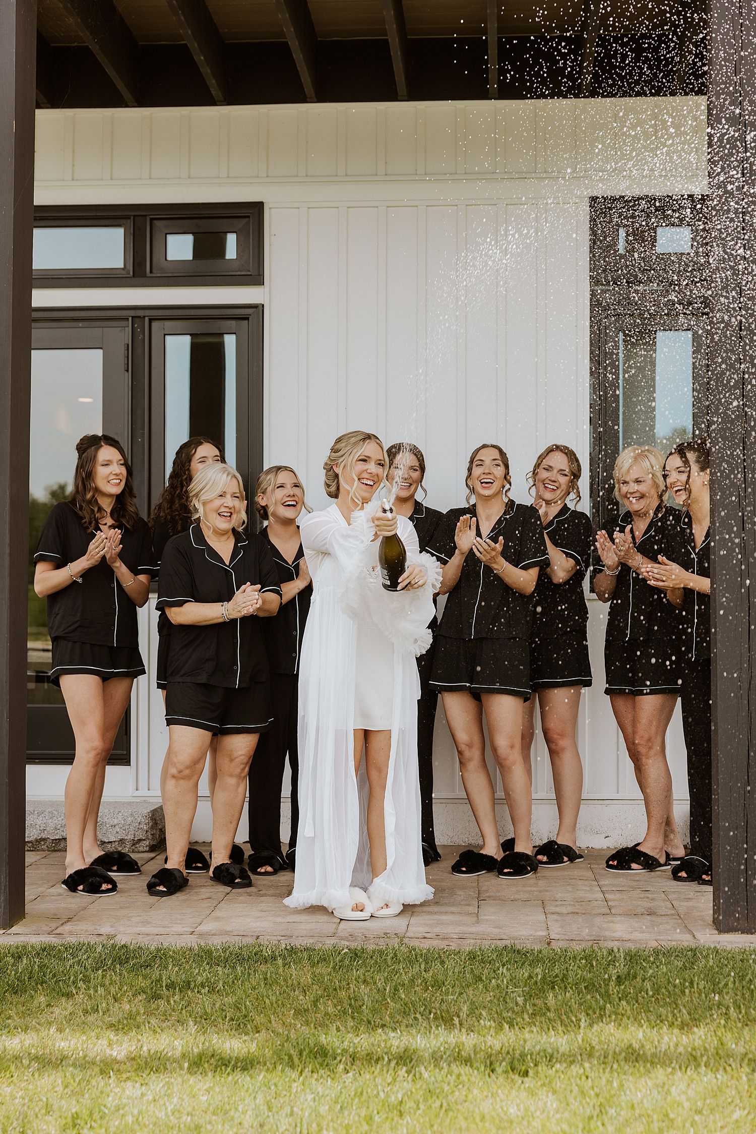 Bride opening champagne with her bridesmaids before her Owl's Nest Resort wedding in NH