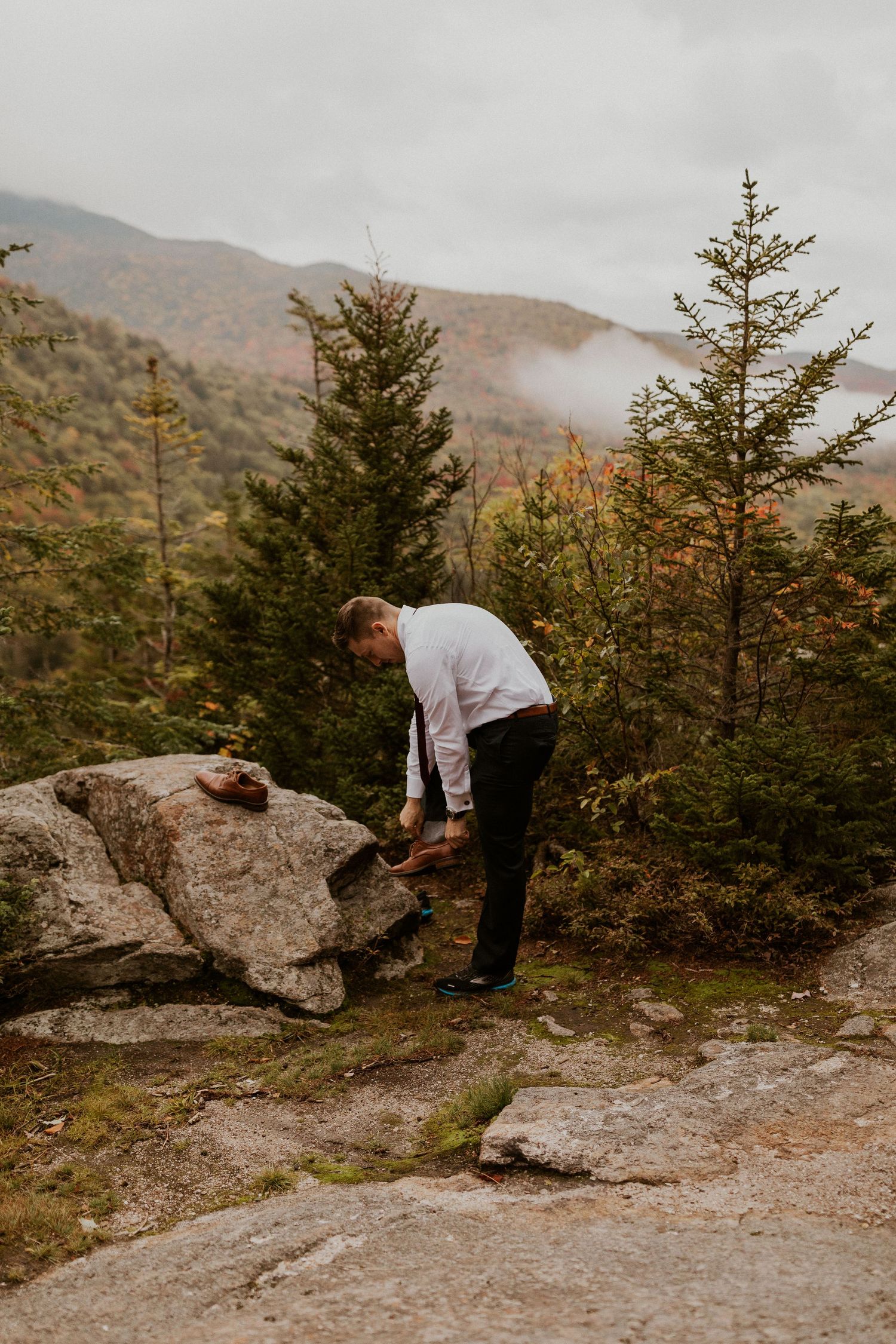 The groom getting ready on the mountain top before seeing his soon to be wife.