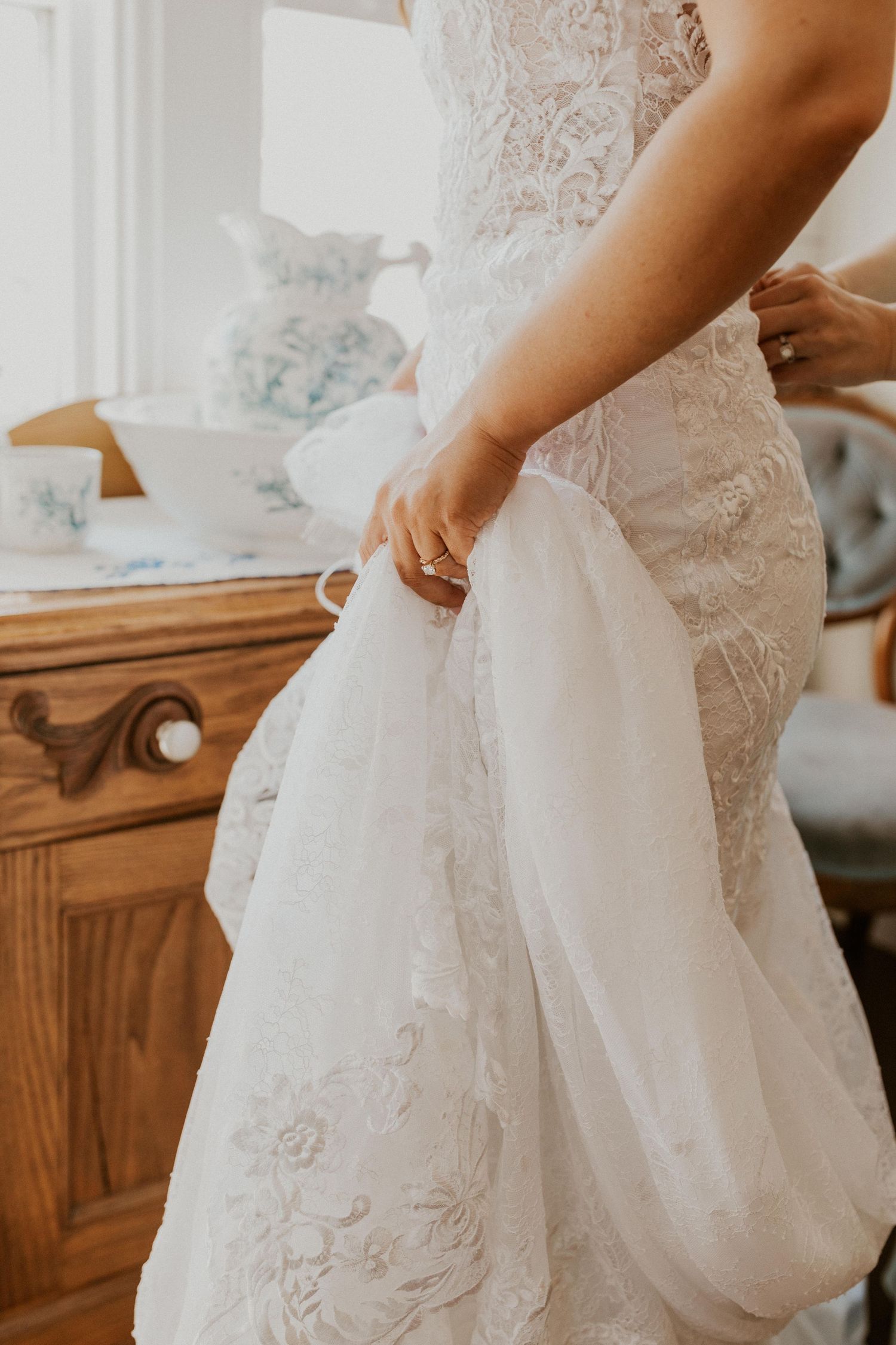 Chrissy holding onto her gown as she gets ready for her wedding