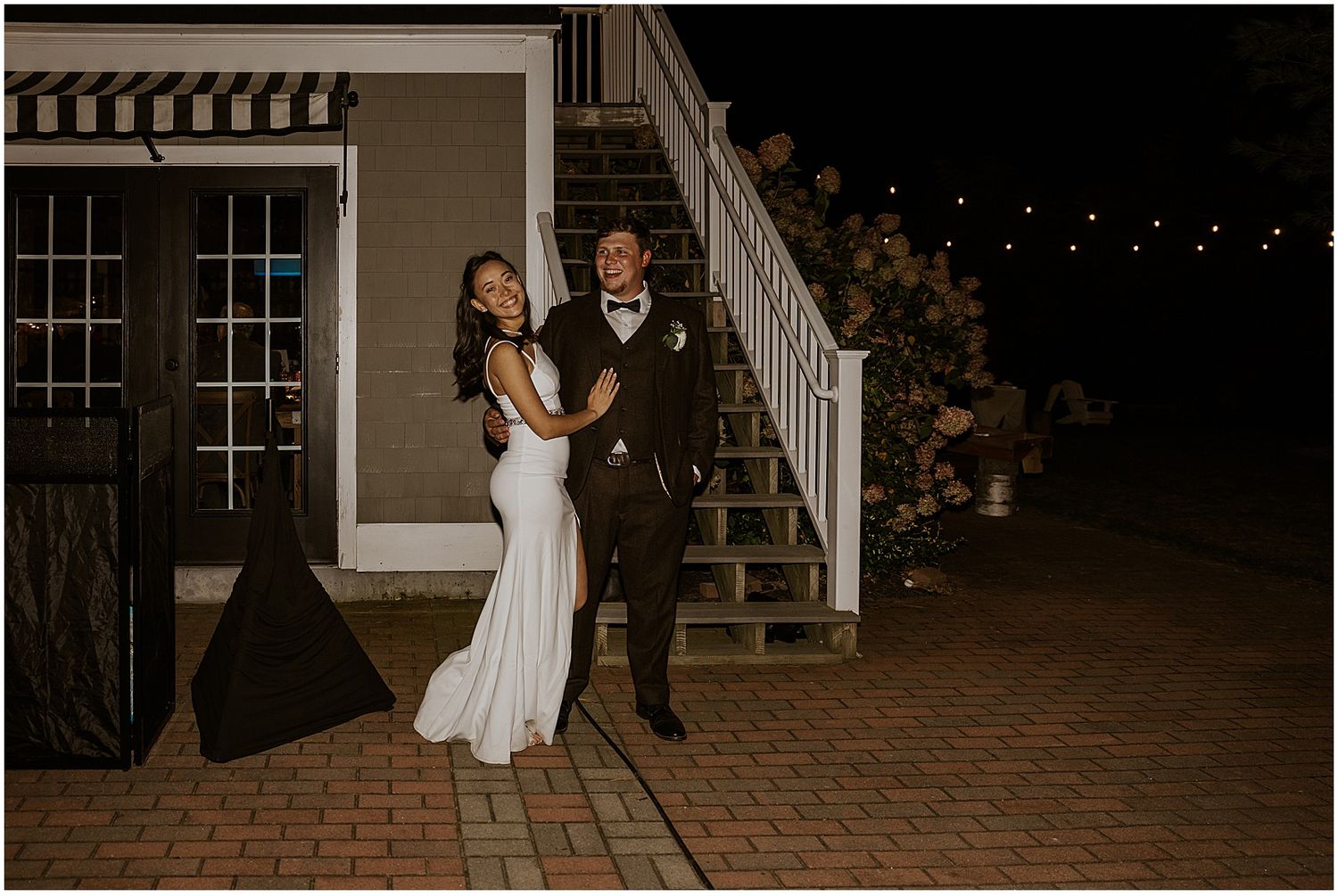 Evening outdoor wedding venue with brick pathway and staircase lit at night.