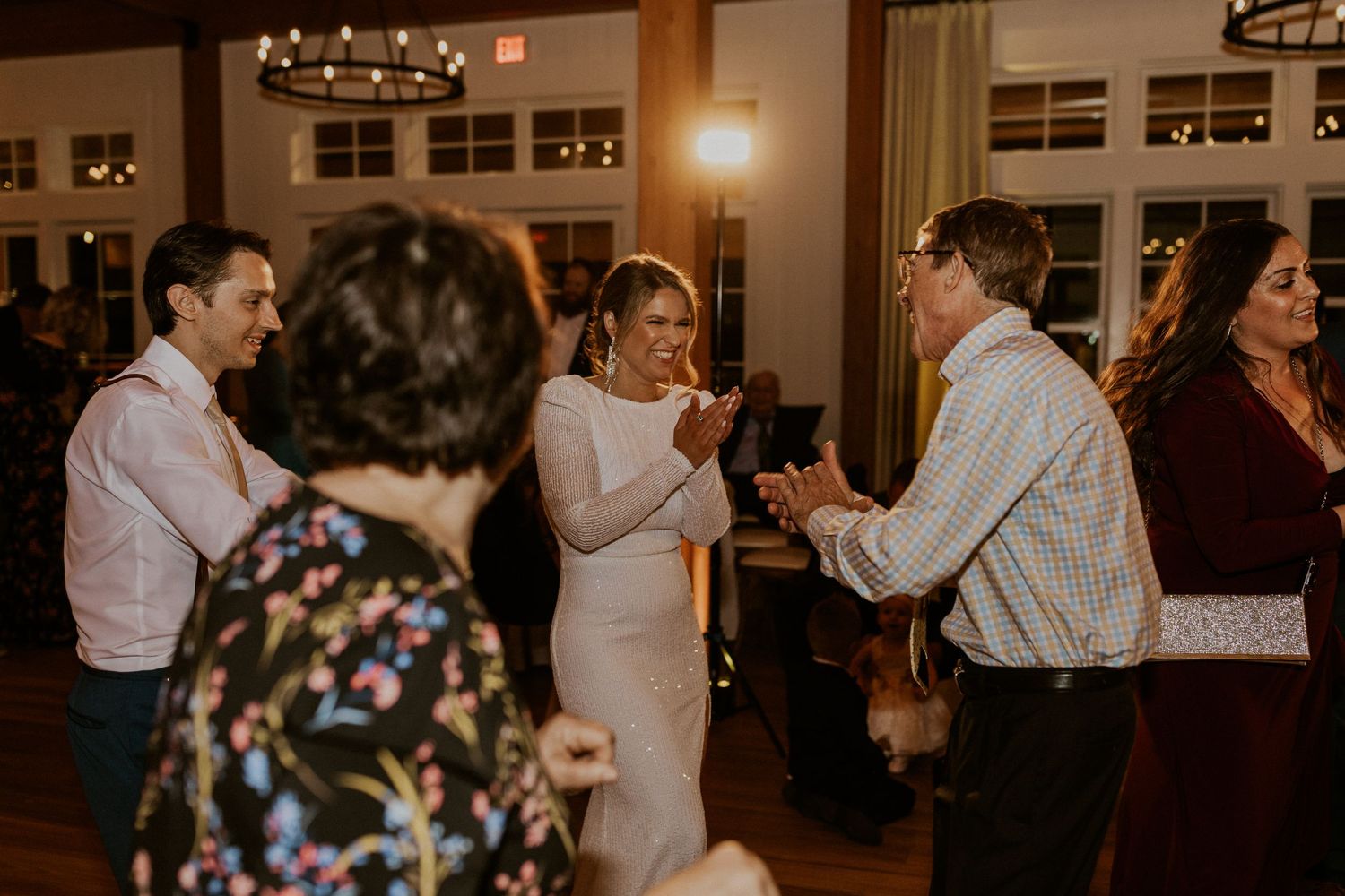 A candid photograph of the bride having fun at the wedding reception held in the Lake House at Owl's Nest Resort