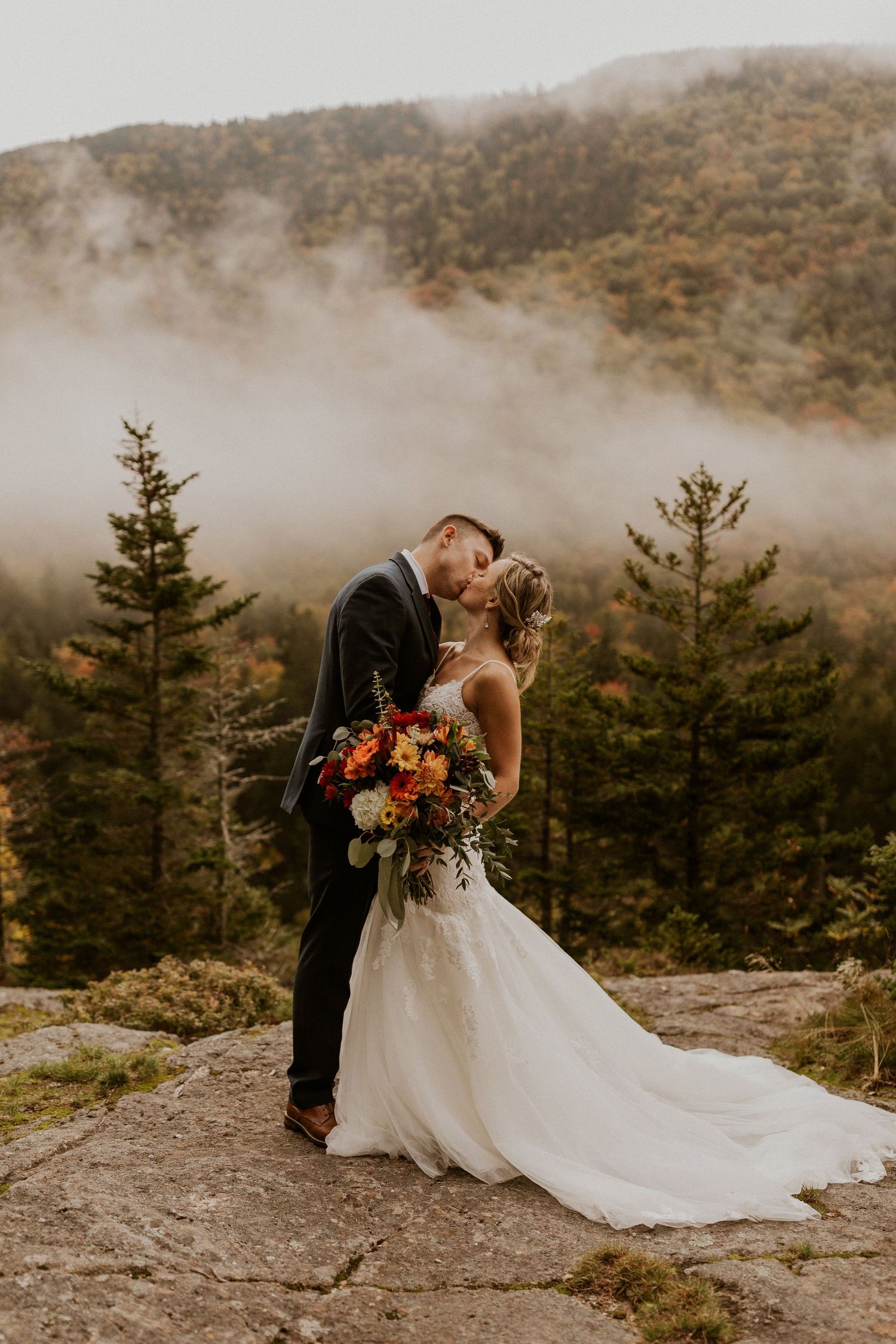 Newlyweds posing for mountaintop portraits in the White Mountain National Forest of New Hampshire.