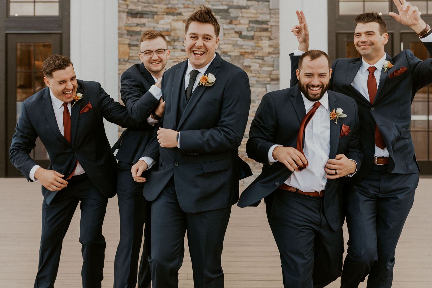 The groom and groomsmen walking together during group portraits.