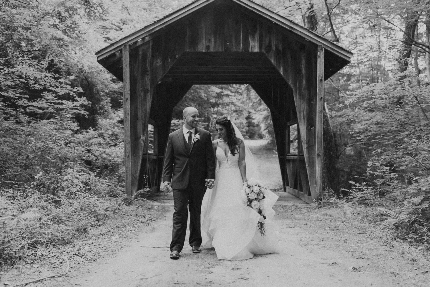 Black and white photos of a rustic covered bridge wedding setting.