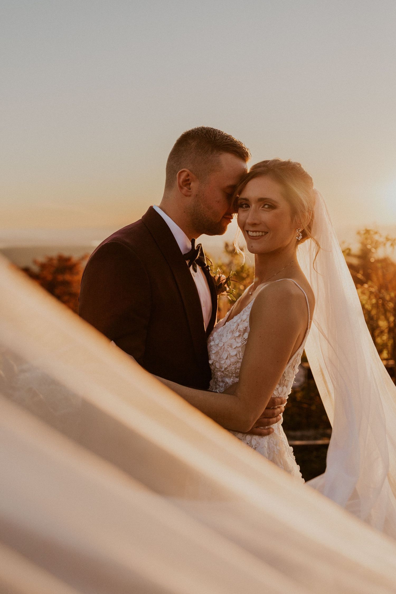 Bride and groom snuggled up together during golden hour portraits at Castle in the Clouds in Moultonborough NH.