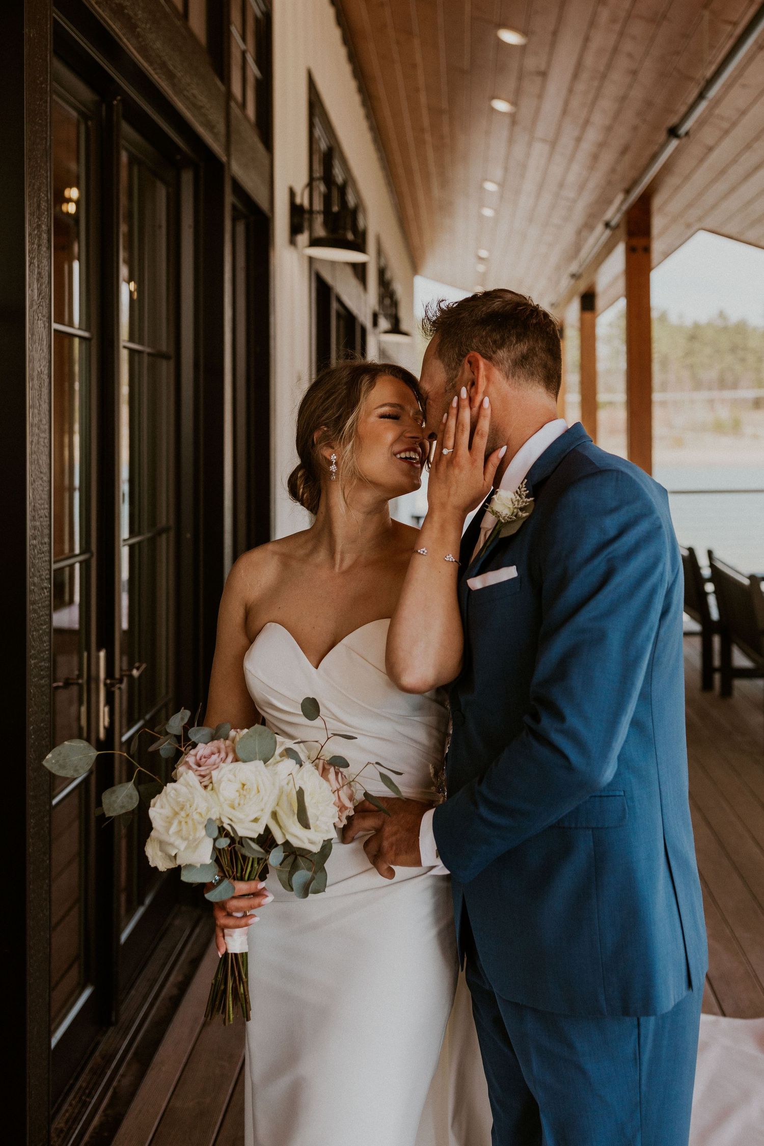 Kendra and Andrew embracing each other and kissing intimately during wedding portraits at the Owl's Nest Lake House.