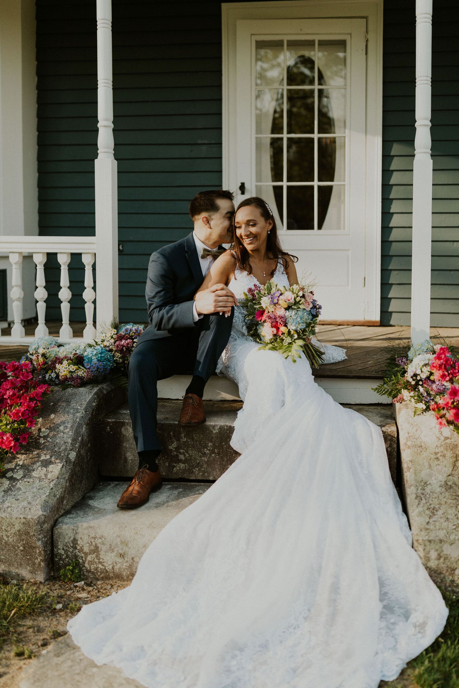 Chrissy and Mike sitting on the front steps of the porch at the Arabella Estate.