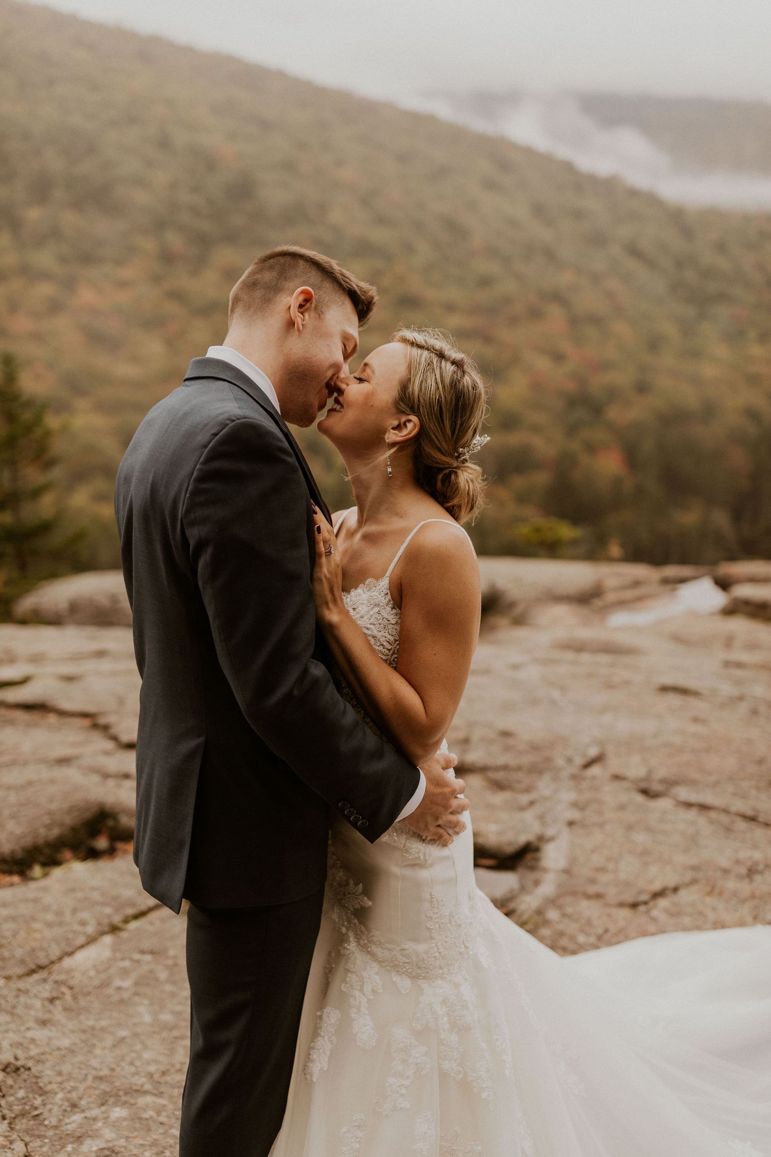 Newlyweds posing for mountaintop portraits in the White Mountain National Forest of New Hampshire.