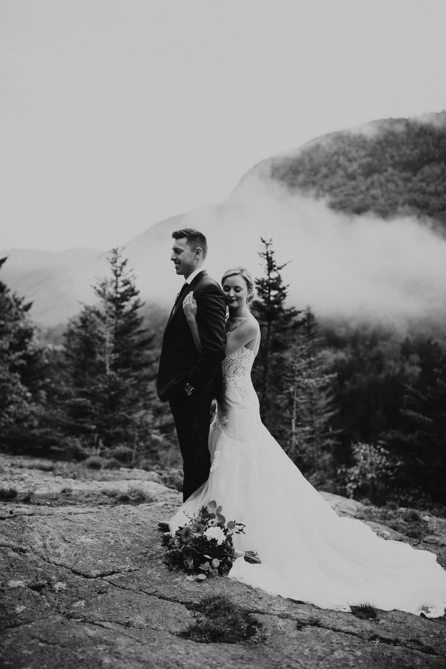 Newlyweds posing for mountaintop portraits in the White Mountain National Forest of New Hampshire.