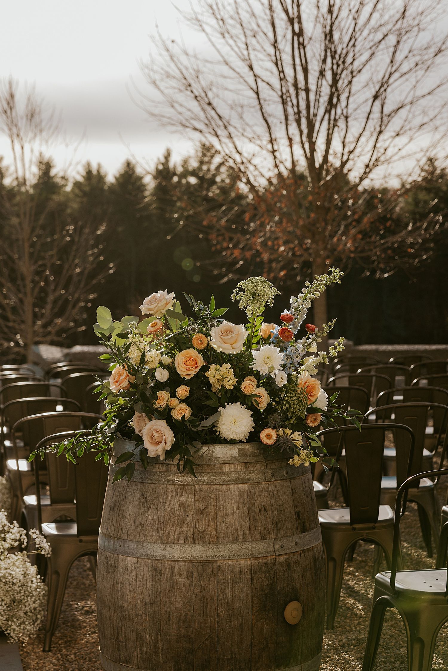 Rustic barrel holding a floral centerpiece for a New Hampshire wedding ceremony at the Barn at Powder Major's Farm