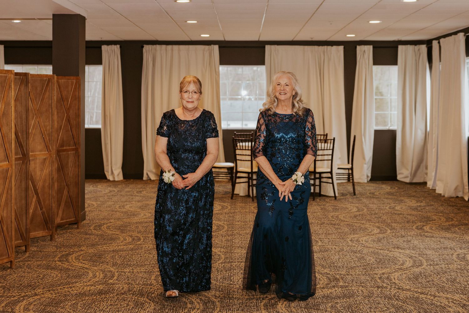 Wedding reception venue with elegant carpeting and wooden accent walls in a spacious banquet hall setup.