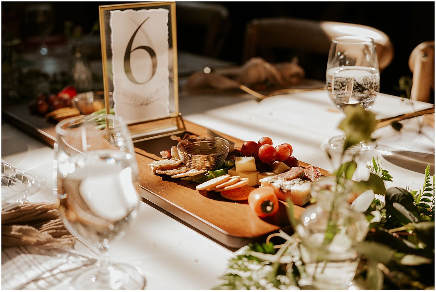 Elegant table settings with floral centerpieces and glassware at rustic barn reception.