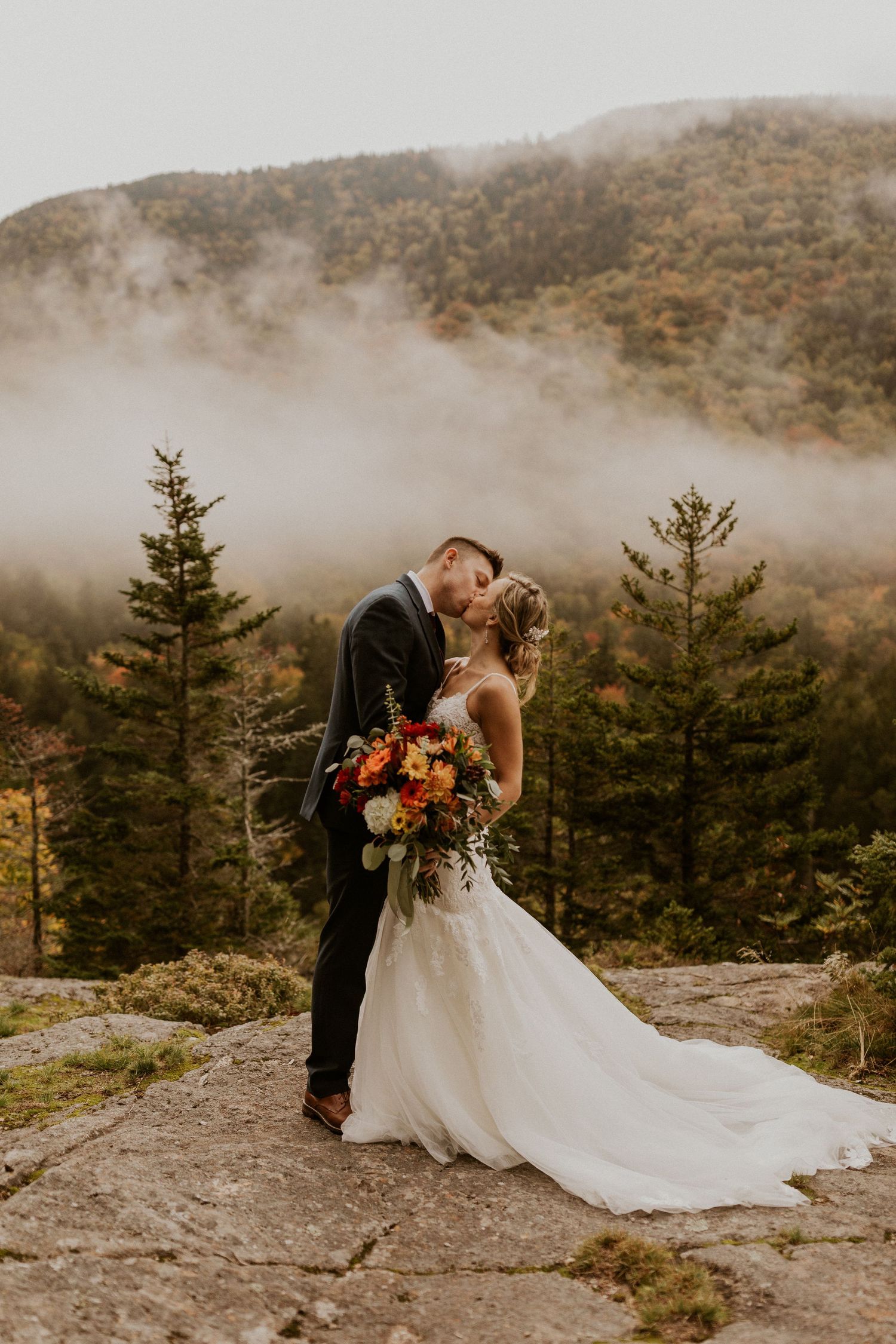Newlyweds posing for mountaintop portraits in the White Mountain National Forest of New Hampshire.