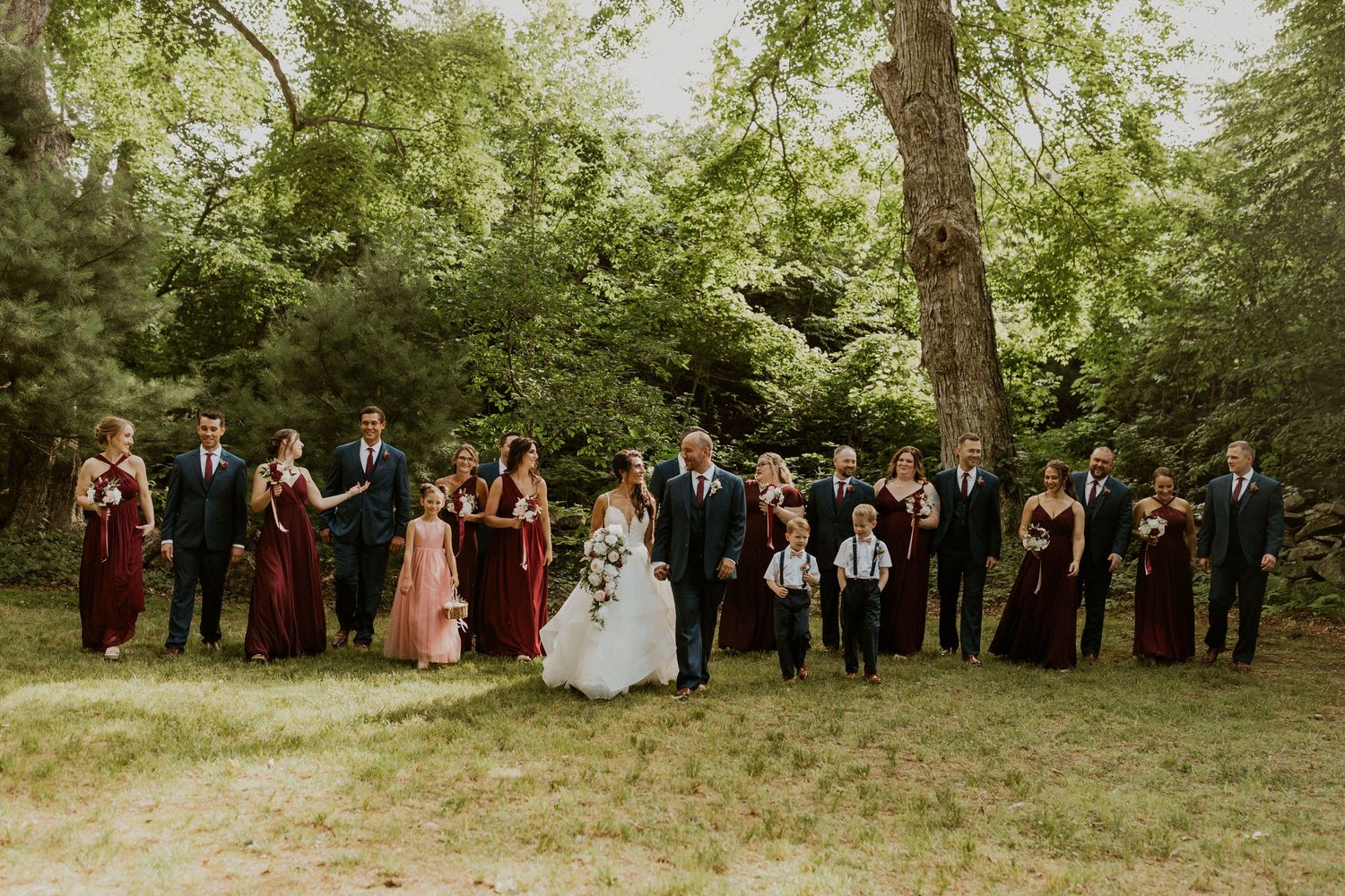 Jessica and Mike walking and talking with their wedding party walking alongside them for a large group photo.