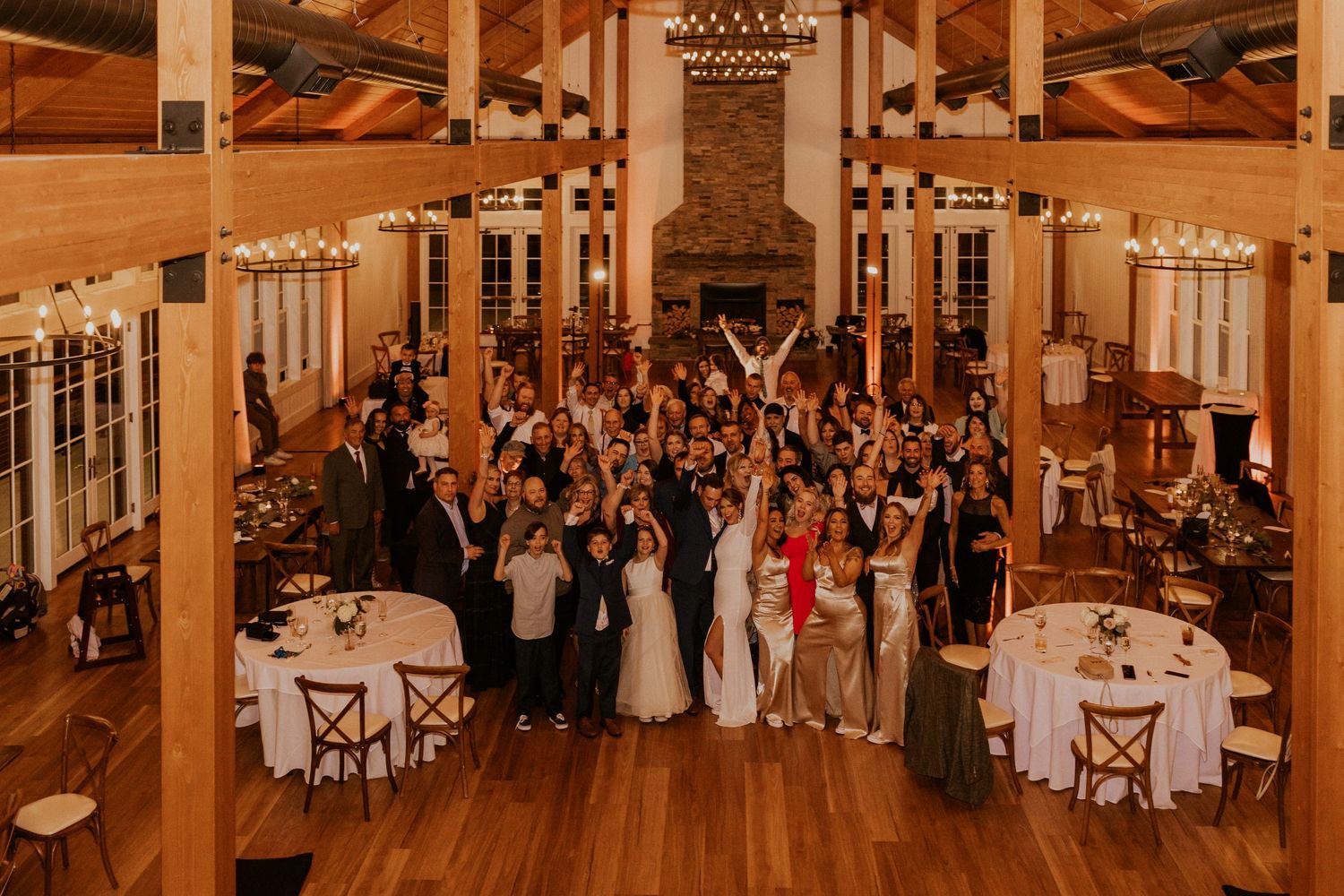A big group photo of all the wedding guests in the Lake House at Owl's Nest Resort