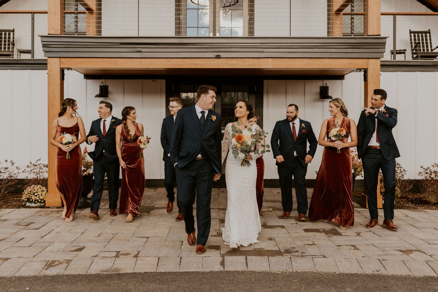 the bride and groom walking and laughing with the whole wedding party at Owl's Nest Resort in Thornton, New Hampshire.