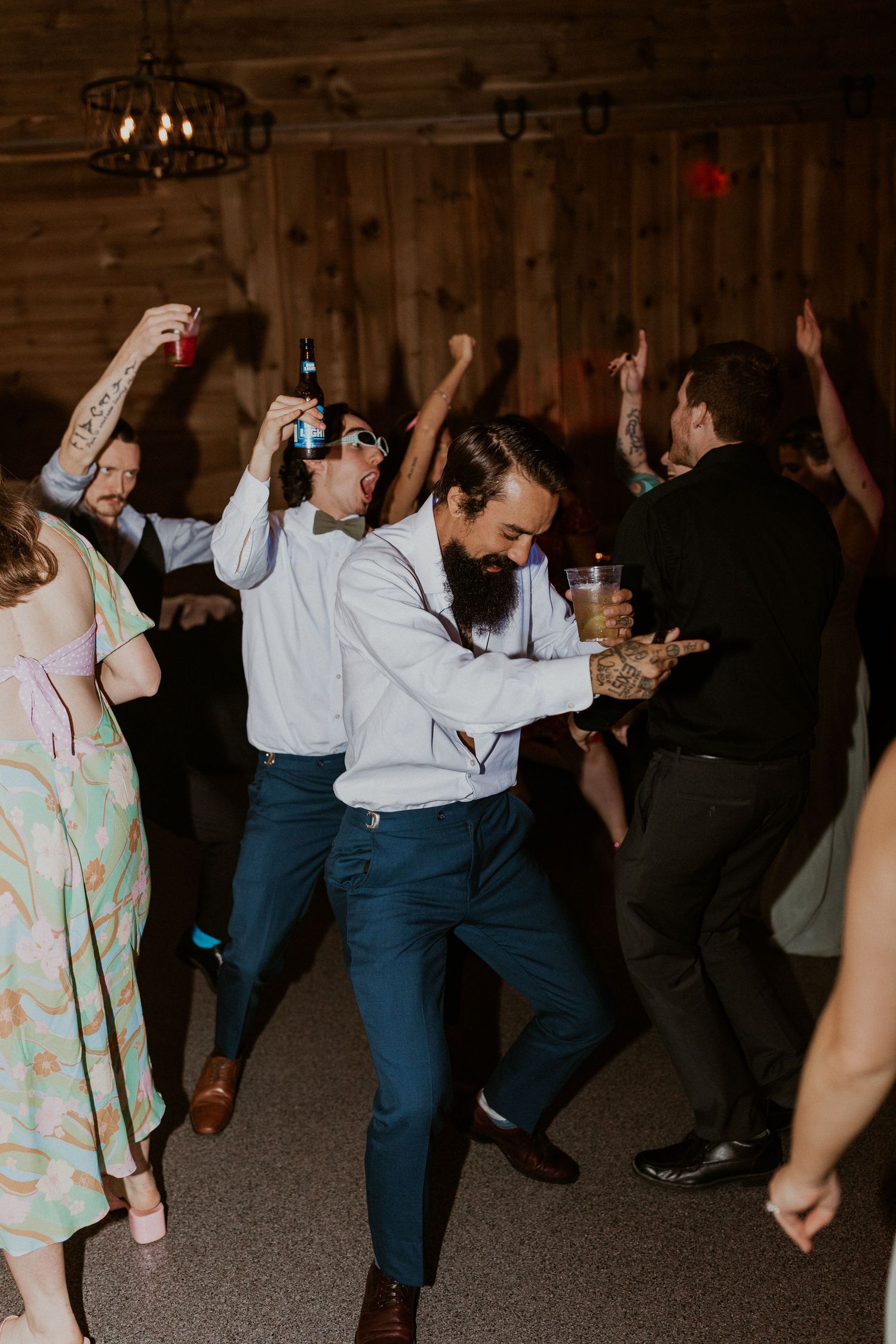 Wedding guests dancing energetically on the dance floor during reception celebrations.