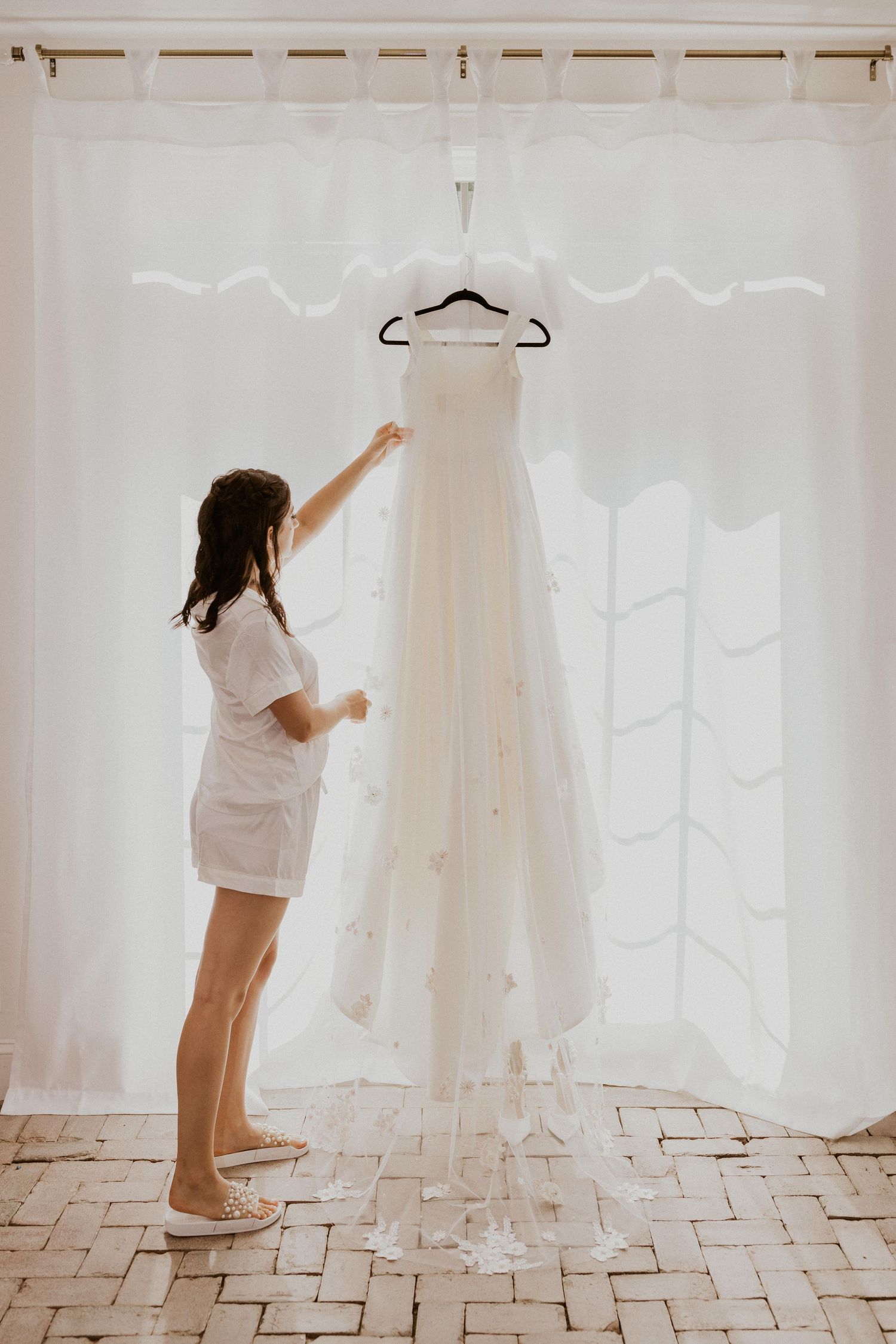 Getting ready sequence showing preparation with wedding dress in bright room.