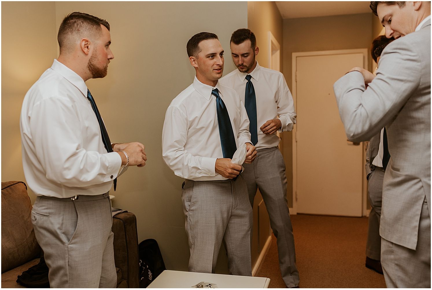 Groomsmen in white shirts and ties preparing for the wedding ceremony.