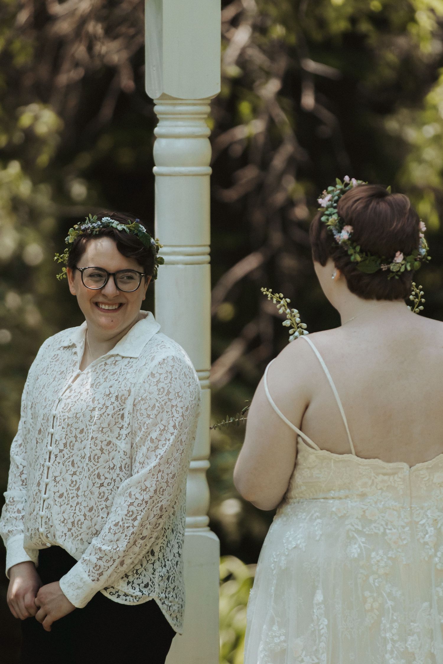 Wedding portraits taken on a porch with white columns and natural lighting.