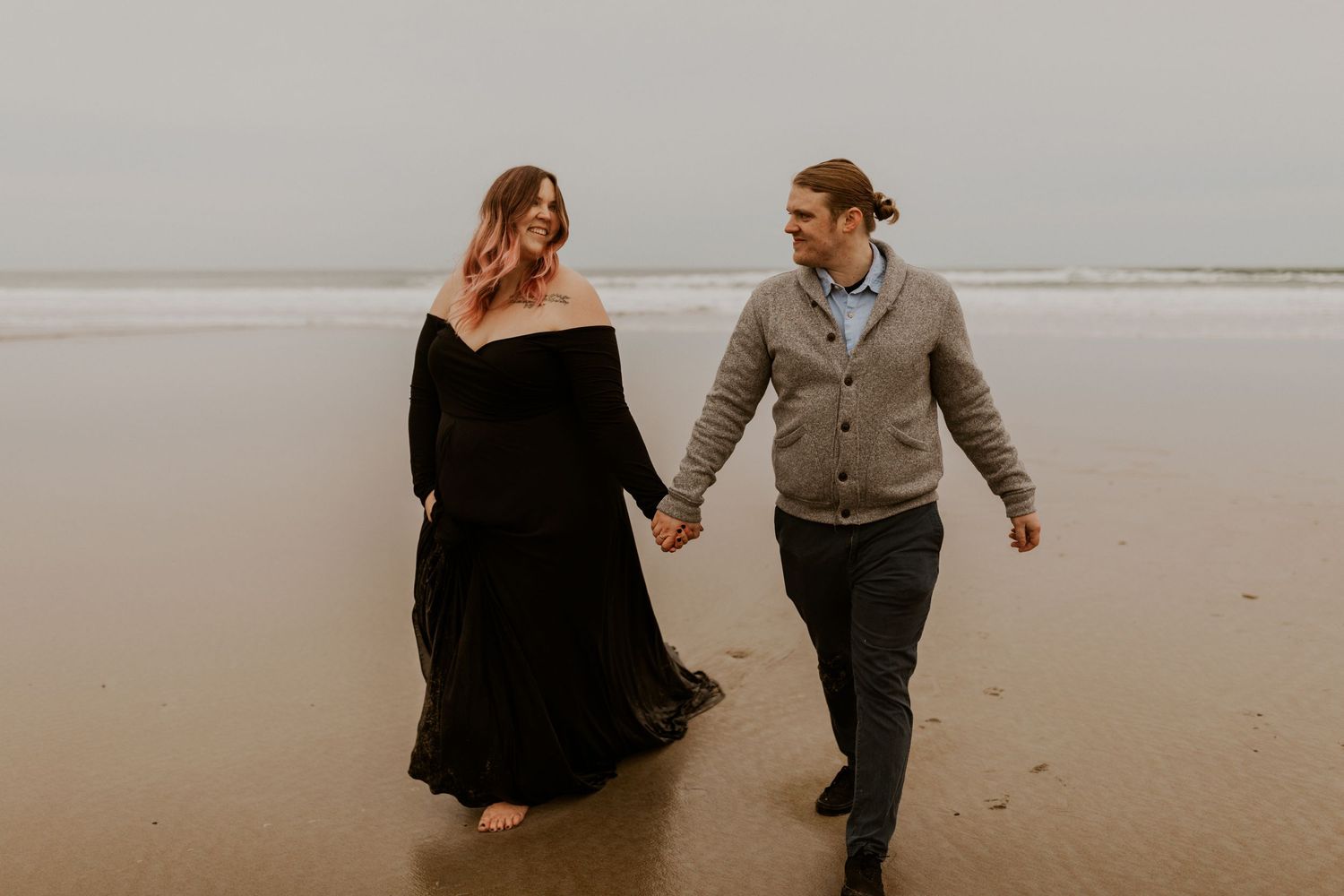 Husband and wife posing for maternity photos on Moody Beach in Wells Maine