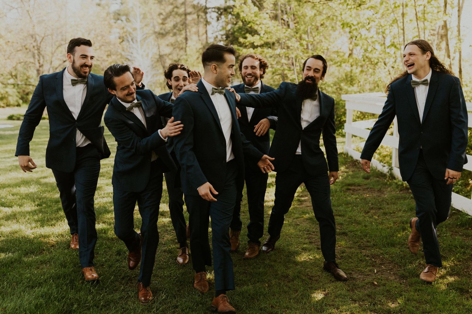 Groomsmen group photo with everyone walking and laughing and having fun together.