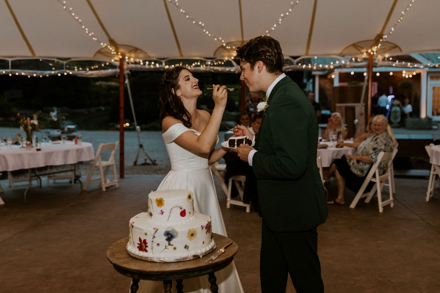 Indoor wedding reception with romantic string light decorations and dancing.